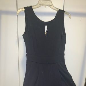 Black jumpsuit with gold zippers at the back legs